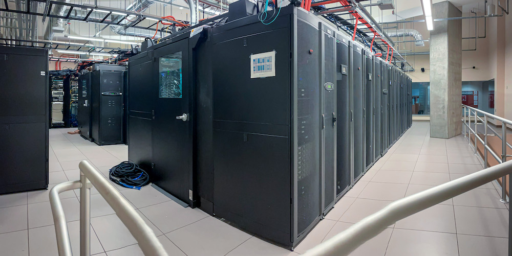 Rows of black server cabinets in a UW–Madison data center operated by the Center for High Throughput Computing.