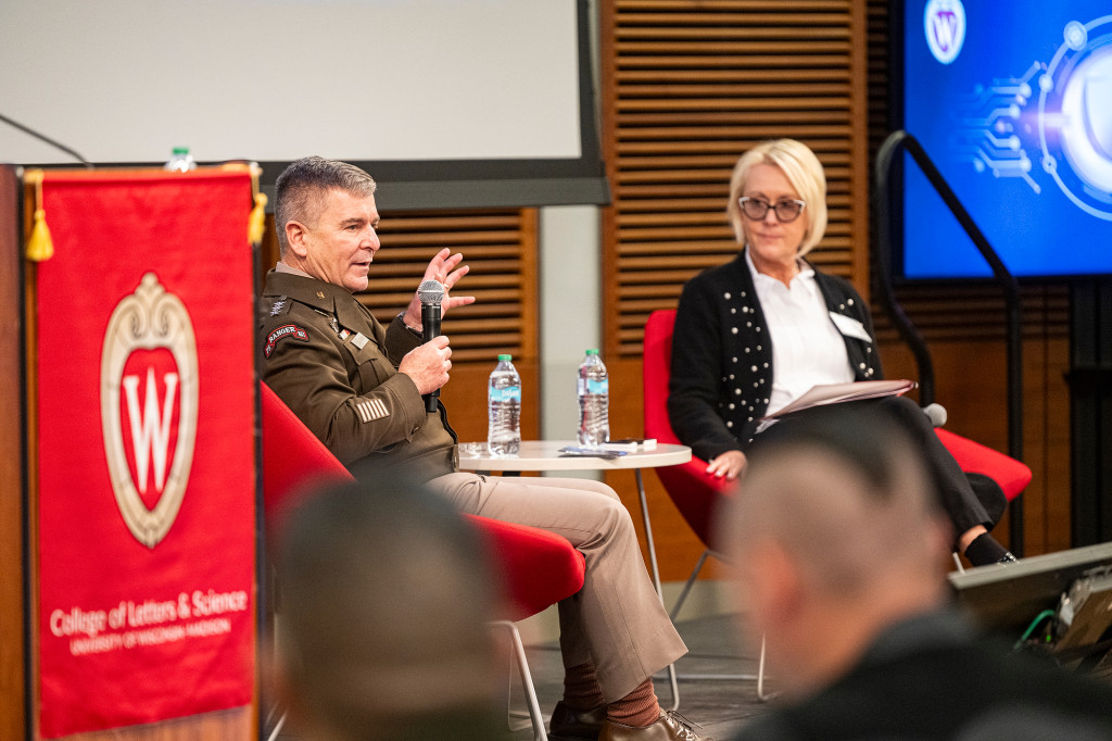 Lt. Gen. Joe Hartman speaks into a microphone alongside Vice Chancellor for Research Dorota Grejner-Brzezińska during an on-stage conversation at UW–Madison.
